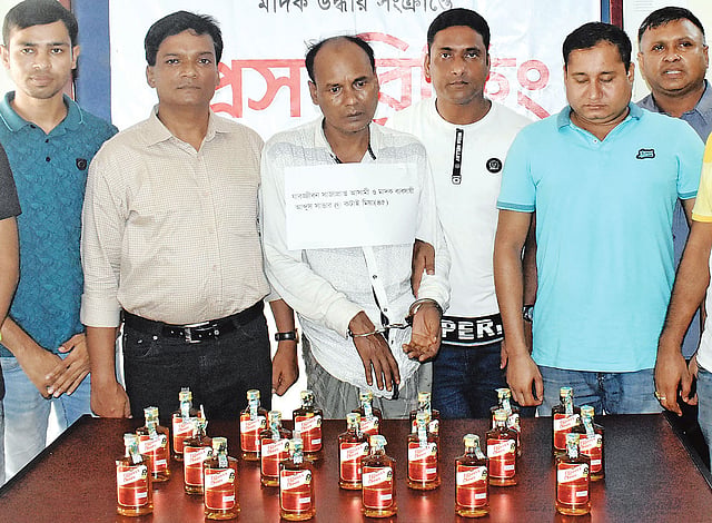গ্রেপ্তারের পর বাড়ি থেকে উদ্ধার করা ভারতীয় মদসহ কনাই মিয়া। গতকাল সকালে জেলা পুলিশের মাদকবিরোধী সেলে।  প্রথম আলো