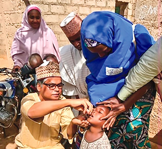 নাইজেরিয়ায় এক শিশুকে পোলিও টিকা খাওয়াচ্ছেন আনিস রহমান সিদ্দিকী