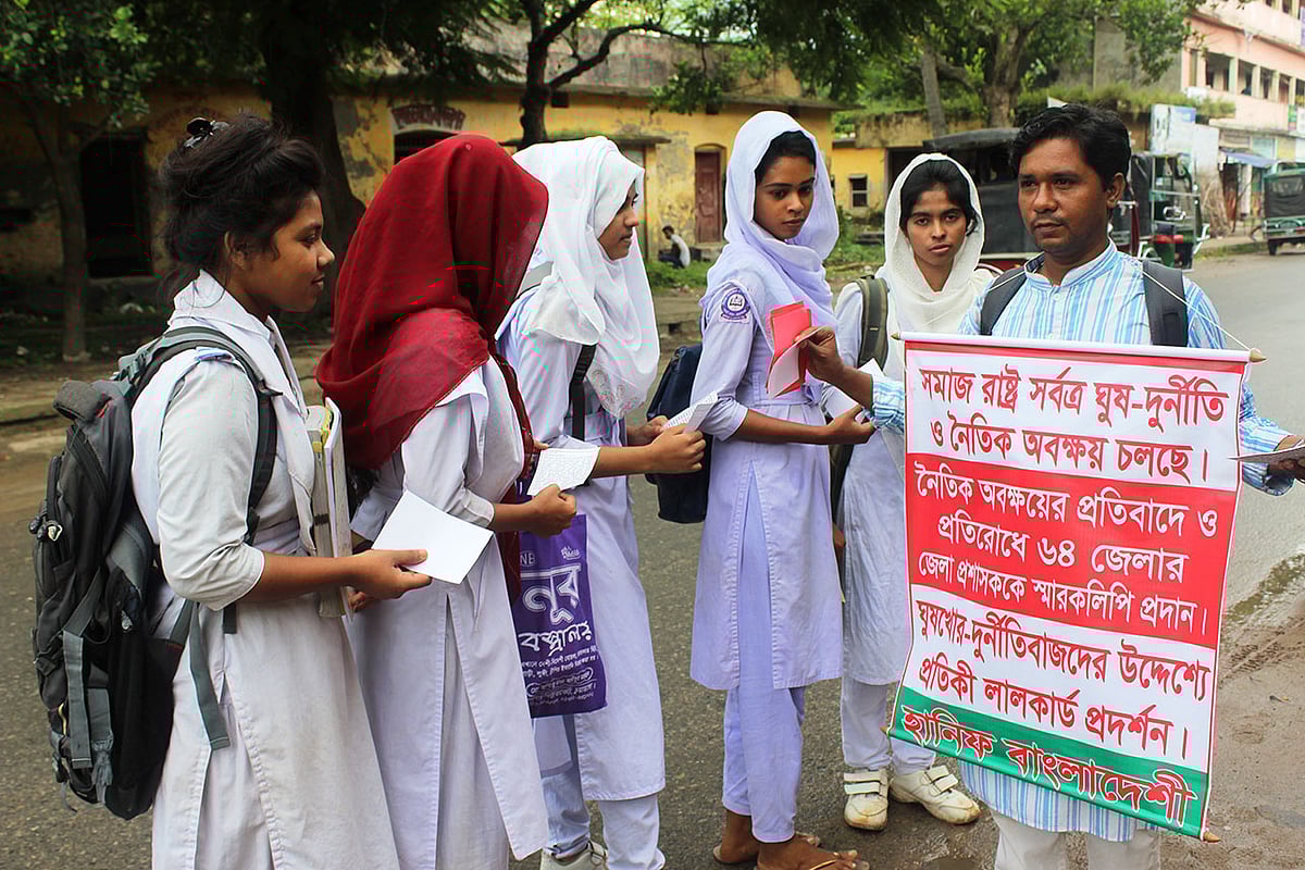 ঘুষ-দুর্নীতি ও নৈতিক অবক্ষয়ের বিষয়ে শিক্ষার্থীদের সচেতন করছেন মো. হানিফ। সেই সঙ্গে ঘুষখোর ও দুর্নীতিবাজদের উদ্দেশ্যে লাল কার্ড প্রদর্শন করেন তিনি। চুয়াডাঙ্গা, ২৪ সেপ্টেম্বর। ছবি: শাহ আলম