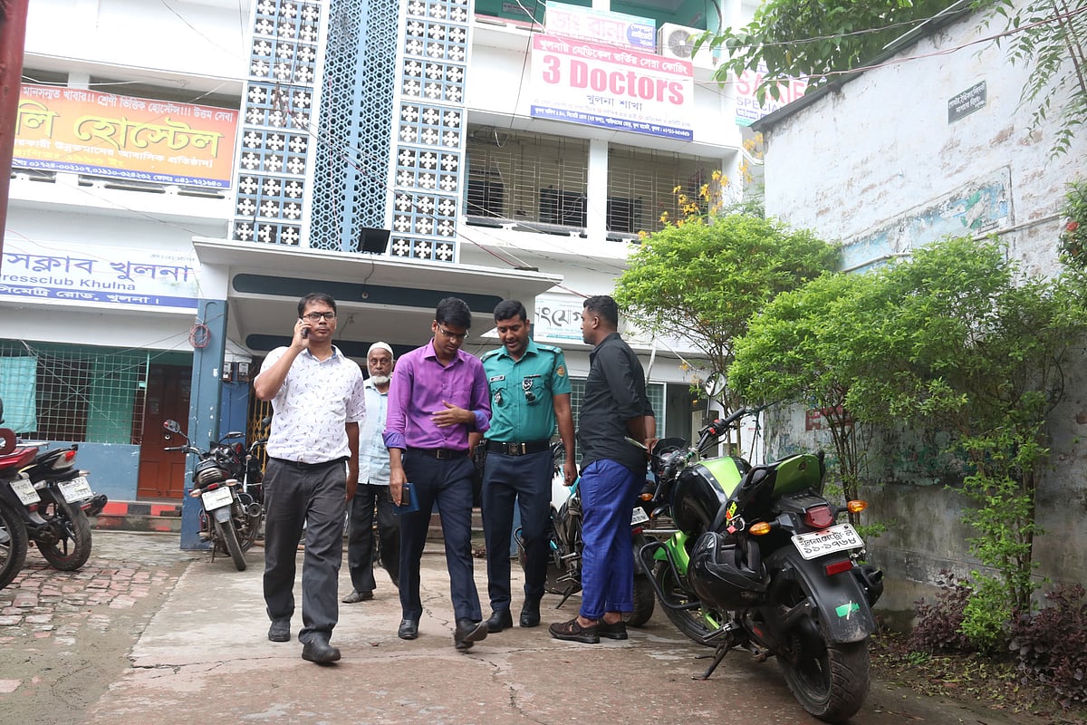 খুলনার মেডিকেল ভর্তি কোচিং থ্রি ডক্টর্সে অভিযান চালায় খুলনা জেলা প্রশাসন। অভিযান শেষে পরিচালক তারিমকে (বামে ফোনে কথা বলছেন) জিজ্ঞাসাবাদের জন্য নিয়ে যাওয়া হচ্ছে। বেণীবাবু সড়ক, খুলনা, ১০ অক্টোবর। ছবি: সাদ্দাম হোসেন