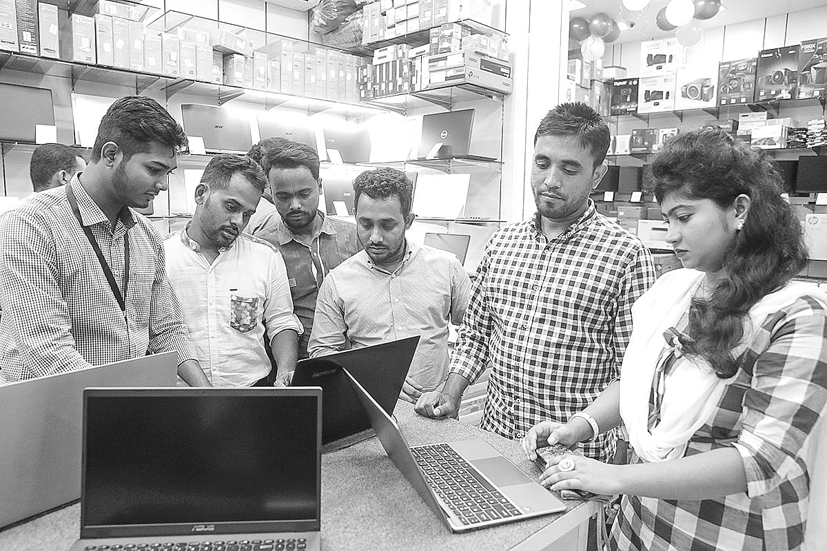 এলিফ্যান্ট রোডের মেলায় প্রযুক্তি পণ্য দেখছেন কয়েকজন দর্শক।  ছবি: প্রথম আলো