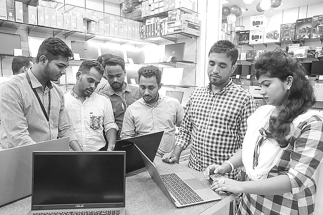 এলিফ্যান্ট রোডের মেলায় প্রযুক্তি পণ্য দেখছেন কয়েকজন দর্শক।  ছবি: প্রথম আলো