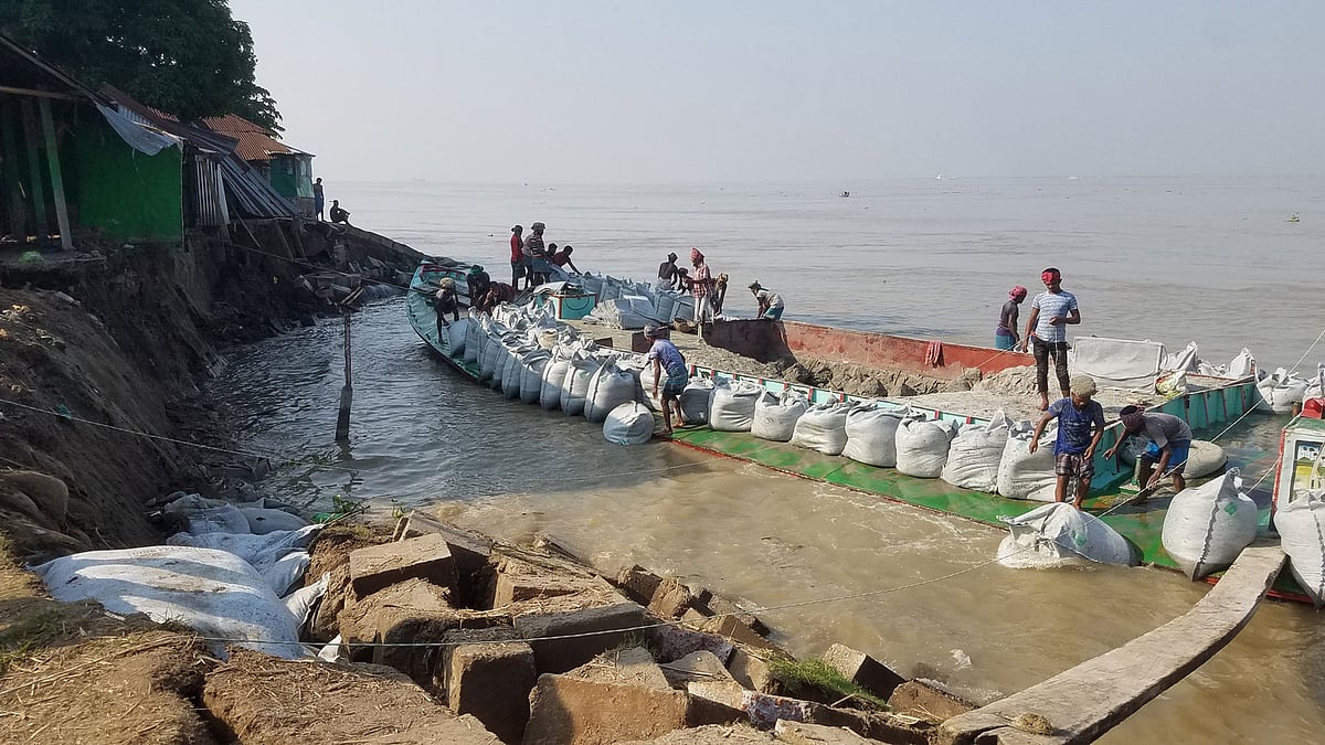গতকাল সোমবার সন্ধ্যার পর থেকে চাঁদপুর শহরের পুরানবাজার হরিসভা এলাকায় শহর রক্ষা বাঁধে মেঘনা নদীর তীব্র স্রোতে প্রায় ৪০ মিটার এলাকা নদীতে দেবে গেছে। ভাঙন রোধে বালির বস্তা ফেলা হয়েছে। ছবি: আলম পলাশ