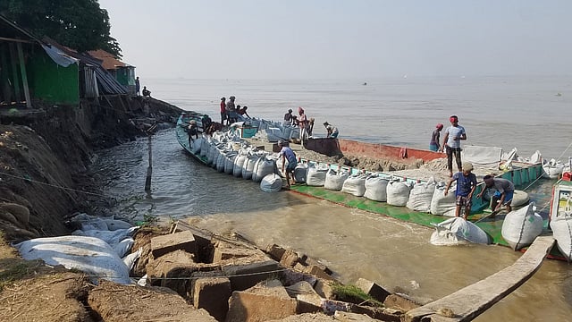 গতকাল সোমবার সন্ধ্যার পর থেকে চাঁদপুর শহরের পুরানবাজার হরিসভা এলাকায় শহর রক্ষা বাঁধে মেঘনা নদীর তীব্র স্রোতে প্রায় ৪০ মিটার এলাকা নদীতে দেবে গেছে। ভাঙন রোধে বালির বস্তা ফেলা হয়েছে। ছবি: আলম পলাশ