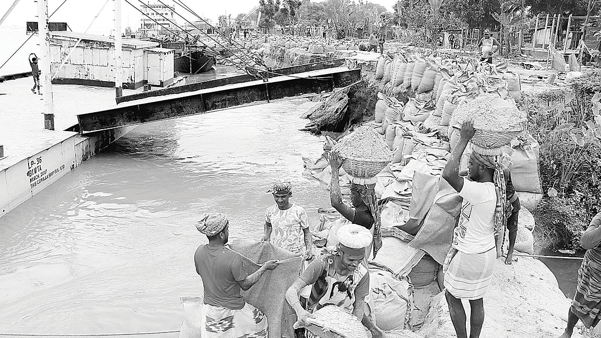 রাজবাড়ীর দৌলতদিয়া ও মানিকগঞ্জের পাটুরিয়া নৌপথে পদ্মার পানি দ্রুত কমছে। এ অবস্থায় ঘাট স্থানান্তর নিয়ে নতুন করে শঙ্কা দেখা দিয়েছে। এ ছাড়া থেমে থেমে ভাঙন অব্যাহত রয়েছে। ভাঙনের কারণে প্রতিটি ঘাটের মাথা নদীতে বিলীন হয়ে গেছে। ভাঙন থেকে রক্ষা করতে ২ নম্বর ঘাট এলাকায় বালুভর্তি বস্তা ফেলা হচ্ছে। গতকাল দুপুরে তোলা। ছবি: প্রথম আলো