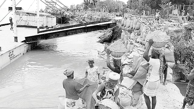 রাজবাড়ীর দৌলতদিয়া ও মানিকগঞ্জের পাটুরিয়া নৌপথে পদ্মার পানি দ্রুত কমছে। এ অবস্থায় ঘাট স্থানান্তর নিয়ে নতুন করে শঙ্কা দেখা দিয়েছে। এ ছাড়া থেমে থেমে ভাঙন অব্যাহত রয়েছে। ভাঙনের কারণে প্রতিটি ঘাটের মাথা নদীতে বিলীন হয়ে গেছে। ভাঙন থেকে রক্ষা করতে ২ নম্বর ঘাট এলাকায় বালুভর্তি বস্তা ফেলা হচ্ছে। গতকাল দুপুরে তোলা।  ছবি:  প্রথম আলো