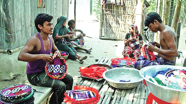 সুতা দিয়ে পাখা তৈরি করছেন নারী-পুরুষেরা। সম্প্রতি গাইবান্ধার সাদুল্যাপুর উপজেলার বুজরুক রসুলপুর গ্রামে।  ছবি: প্রথম আলো