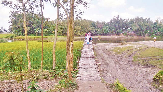 সানিয়ারজান নদে সেতু না থাকায় লোকজন বাঁশের সাঁকো দিয়ে চলাচল করছে। সম্প্রতি পাটগ্রাম উপজেলার জোড়াপুল গ্রামে।  ছবি: প্রথম আলো