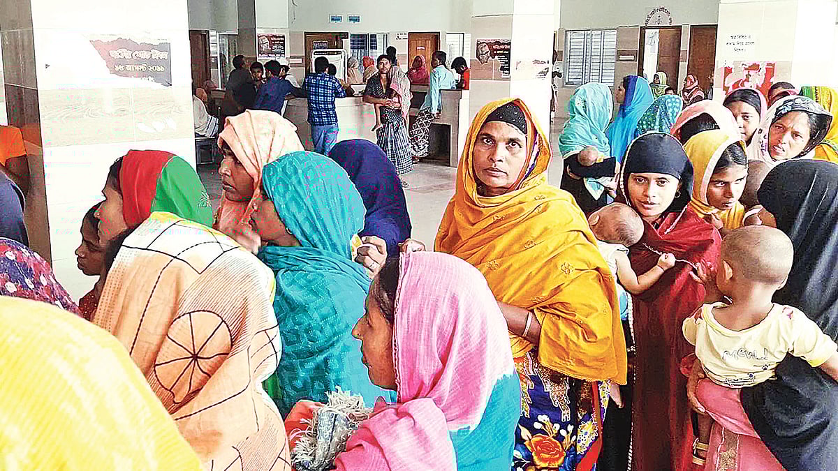 চাঁপাইনবাবগঞ্জ সদর হাসপাতালের বহির্বিভাগে চিকিৎসা নিতে আসা রোগীদের সারি। কয়েক ঘণ্টা অপেক্ষার পর তবেই মিলছে সেবা। গত শনিবার দুপুরে তোলা ছবি।  প্রথম আলো