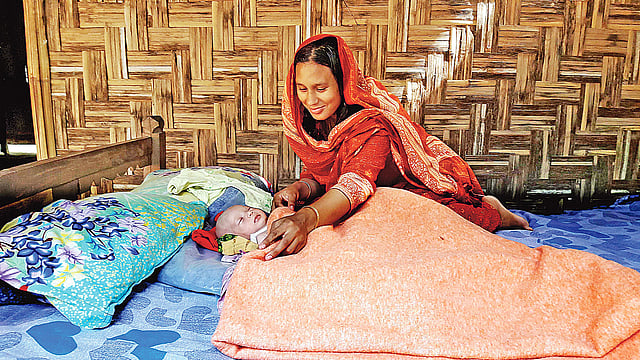 নবজাতক রাজকুমারী রুমঝুমকে ঘুম পাড়াচ্ছেন মা রিমু আক্তার। গতকাল পঞ্চগড় সদর উপজেলার অমরখানা ইউনিয়নের ভীতরগড়-খালপাড়া এলাকায় নানার বাড়িতে।  ছবি: প্রথম আলো