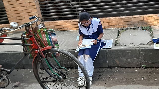 রাজধানীর লালমাটিয়া উচ্চ বালিকা বিদ্যালয়ের সামনে এক শিক্ষার্থী পরীক্ষা শুরুর আগে পড়ছে। ছবি: মানসুরা হোসাইন