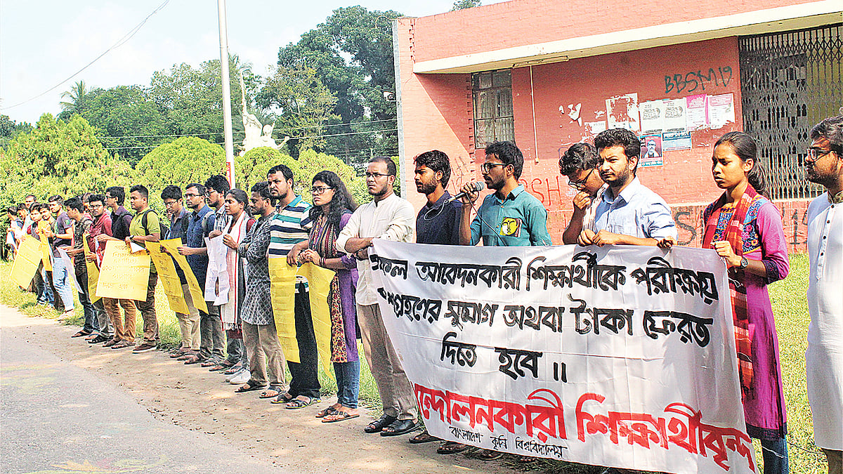 সব আবেদনকারীকে ভর্তি পরীক্ষায় অংশ নেওয়ার সুযোগ অথবা অনির্বাচিত শিক্ষার্থীদের টাকা ফেরত দেওয়ার দাবিতে মানববন্ধন। গতকাল বাংলাদেশ কৃষি বিশ্ববিদ্যালয় ক্যাম্পাসে। ছবি: প্রথম আলো