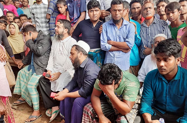 ট্রেন দুর্ঘটনায় নিহত মুজিবুর–কুলসুম দম্পতির দুই ছেলে (ডানে) বায়েক সরকারি প্রাথমিক বিদ্যালয় মাঠে রাখা বেঞ্চে বসে রয়েছেন। পাশে চাচারা । ছবি: প্রথম আলো