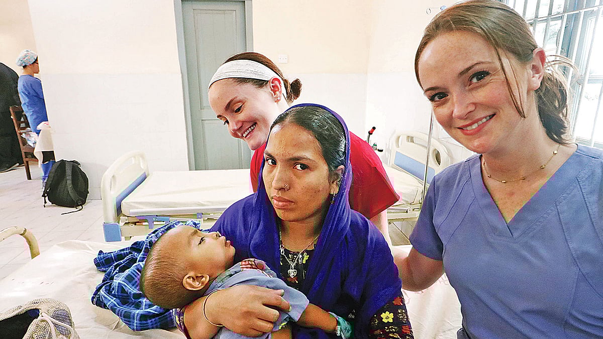 অস্ত্রোপচারের পর এক শিশুর সঙ্গে চিকিৎসা ক্যাম্পের সদস্যরা। গতকাল সিলেট নগরের চৌহাট্টা এলাকার শহীদ সামসুদ্দীন আহমদ হাসপাতালে। ছবি: প্রথম আলো