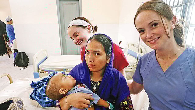 অস্ত্রোপচারের পর এক শিশুর সঙ্গে চিকিৎসা ক্যাম্পের সদস্যরা। গতকাল সিলেট নগরের চৌহাট্টা এলাকার শহীদ সামসুদ্দীন আহমদ হাসপাতালে।  ছবি: প্রথম আলো