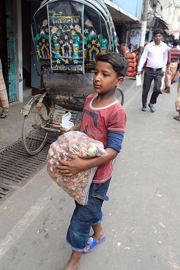 কুড়িয়ে পাওয়া পেঁয়াজ বিক্রি করে দিনে ৫০০ টাকা পর্যন্ত আয় হচ্ছে এই পথশিশুদের। বৃহস্পতিবার বিকেলে তোলা ছবি। ছবি: জুয়েল শীল
