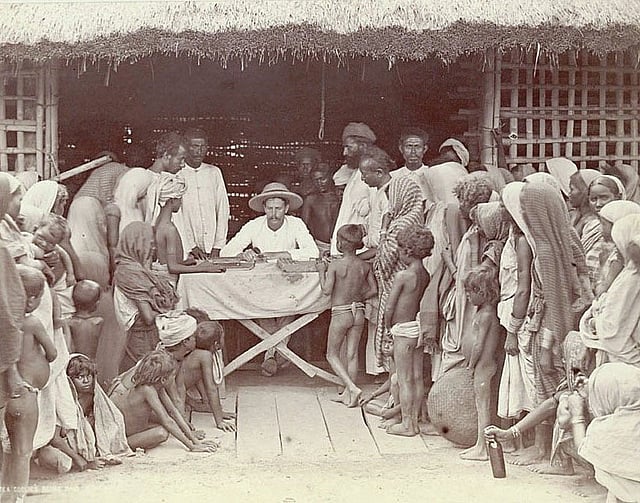 ইউরোপিয়ান ম্যানেজার কর্তৃক আসামের একটি চা-বাগানে শ্রমিকদের মজুরি দেওয়ার দৃশ্য। চিত্রগ্রাহক এমা অগাস্টা কোচ, ছবিটি যুক্তরাষ্ট্রের স্মিথসোনিয়ান ইনস্টিটিউটের ন্যাশনাল এনথ্রোপলজিক্যাল আর্কাইভস থেকে নেওয়া।