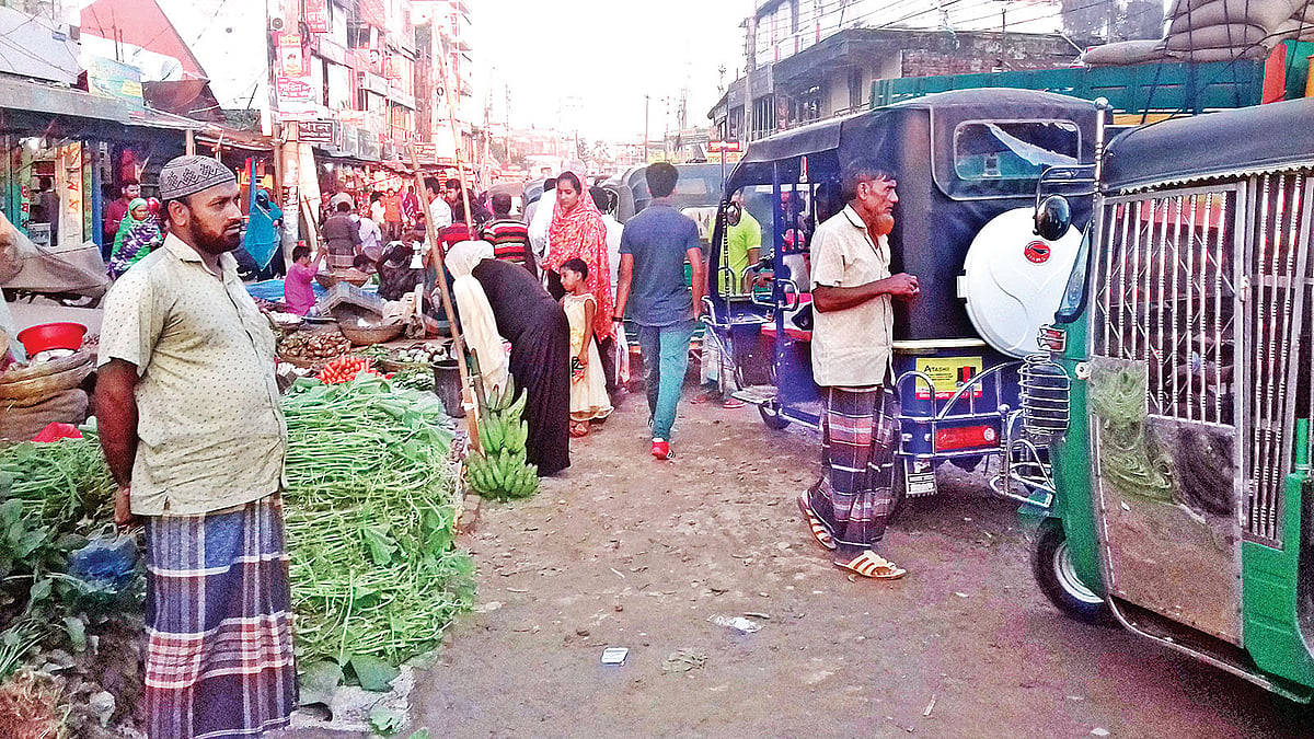 রাস্তার পাশে পণ্যের পসরা সাজিয়ে বসেছেন দোকানিরা। গতকাল বিকেলে ময়মনসিংহের ভালুকা পৌরসভার পাঁচ রাস্তার মোড়ে। ছবি: প্রথম আলো