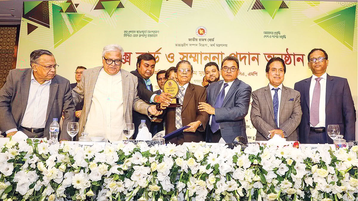 অর্থমন্ত্রী আ হ ম মুস্তফা কামালসহ অন্যদের কাছ থেকে সেরা করদাতার সম্মাননা নিচ্ছেন কাউছ মিয়া। গত বৃহস্পতিবার রাজধানীর র্যাডিসন হোটেলে। ছবি: প্রথম আলো