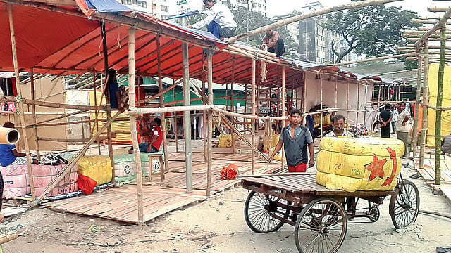 বুড়িগঙ্গার তীরে তৈরি করা হচ্ছে দোকান। গতকাল দুপুরে সদরঘাট এলাকায়।  ছবি: প্রথম আলো