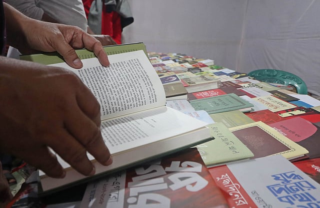 কেনার আগে বইয়ের পাতায় চোখ বুলিয়ে নিচ্ছেন ক্রেতা।