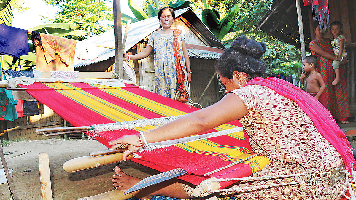 জরি ও সুতা দিয়ে পরনের কাপড় রিনাই তৈরি করছেন ত্রিপুরা নারীরা। গত ২৮ নভেম্বর খাগড়াছড়ি সদর উপজেলার বাঙ্গালকাটিমুখ ত্রিপুরাপাড়ায়। ছবি: নীরব চৌধুরী