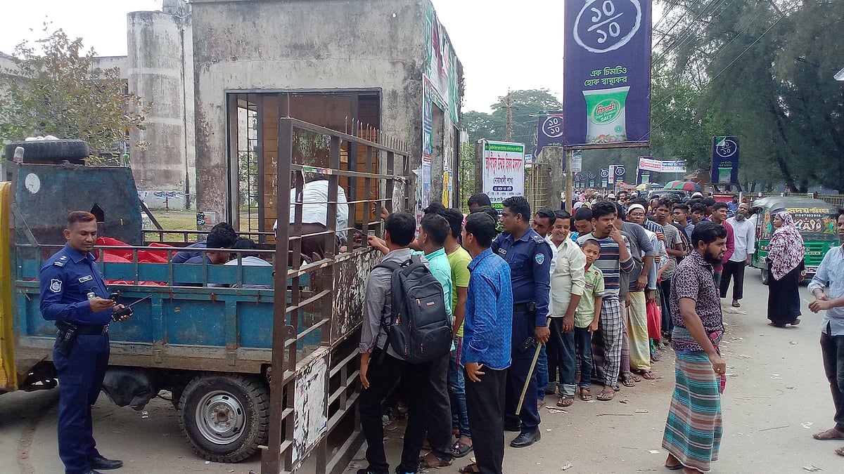 নোয়াখালী শহরের শিল্পকলা একাডেমির ফটকে টিসিবির পেঁয়াজ বিক্রির সময় ভিড় সামলাতে আছে পুলিশ। ছবি: প্রথম আলো