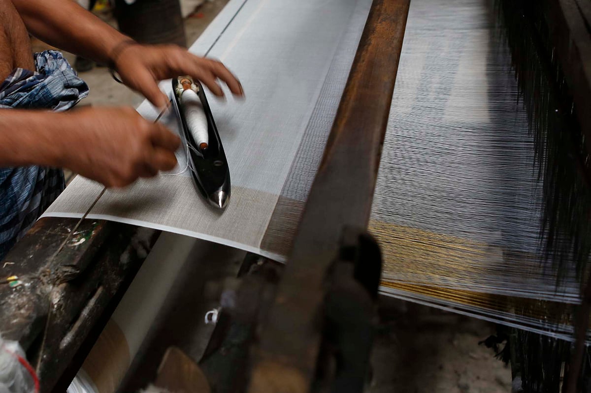 কারিগর দক্ষতার সঙ্গে মাক্কুতে সুতা ভরে বুনে চলেন কাপড়।