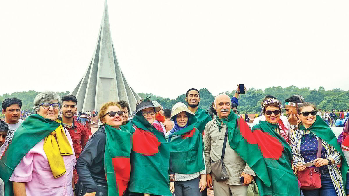 বিজয় উৎসব দেখতে তুরস্ক থেকে বাংলাদেশে বেড়াতে এসেছে ১৩ জনের একটি পর্যটক দল। বাংলাদেশের জাতীয় পতাকা গায়ে জড়িয়ে কুয়াশাচ্ছন্ন সাতসকালে ৪৯তম বিজয় দিবস উদ্‌যাপন করলেন তাঁরা। গতকাল সাভারে জাতীয় স্মৃতিসৌধে।  ছবি: সাইফুল ইসলাম