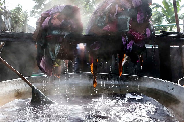 গরম পানির সাহায্যে বিশেষ পদ্ধতিতে রং করার পর তুলে রাখা হচ্ছে কাপড়।