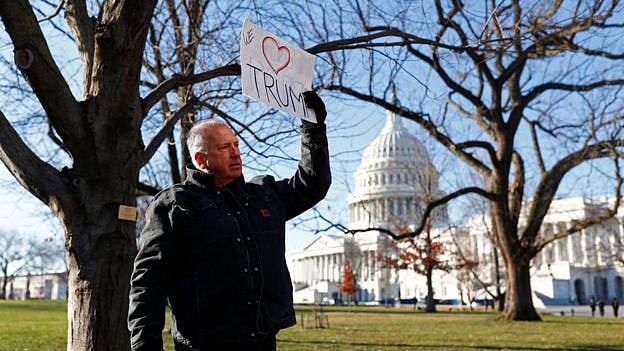 ট্রাম্পের প্রতি ভালোবাসার প্রতীক প্রদর্শন করছেন এক সমর্থক। ছবি: রয়টার্স
