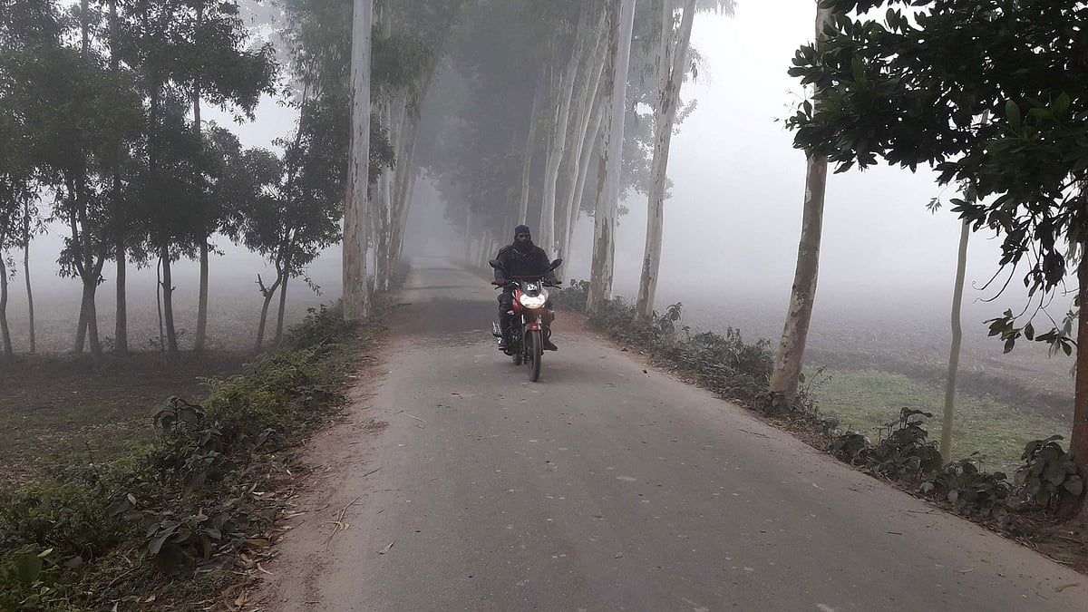 পঞ্চগড়ে ঘন কুয়াশায় ঢেকে গেছে চারদিক। দিনের বেলাও হেডলাইট জ্বেলে মোটরসাইকেল চালাচ্ছেন এক ব্যক্তি। ডুডুমারী এলাকা, সদর উপজেলা, ১৯ ডিসেম্বর। ছবি: রাজিউর রহমান