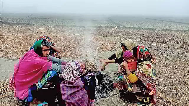 খড়কুটা জ্বালিয়ে শীত নিবারণের চেষ্টা। গতকাল কুড়িগ্রামের ভূরুঙ্গামারী উপজেলার পাথরডুবি এলাকায়। ছবি: প্রথম আলো