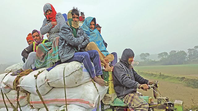 শীতে জবুথবু অবস্থা। পণ্যবাহী যানের ওপর ঠান্ডা বাতাসের মধ্য দিয়ে গন্তব্যে যাচ্ছেন শ্রমজীবী মানুষ। গতকাল সকালে রাজবাড়ীর গোয়ালন্দে।  ছবি: প্রথম আলো