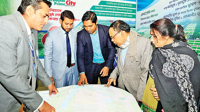পূর্বাচল প্রাইম সিটি প্রকল্পের মানচিত্র দেখছেন কয়েকজন ক্রেতা।  ছবি: প্রথম আলো