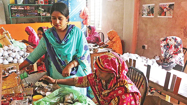 কারখানায় এক কর্মীকে কাজ বুঝিয়ে দিচ্ছেন মরিয়ম আক্তার (দাঁড়ানো)।  ছবি: দিনার মাহমুদ
