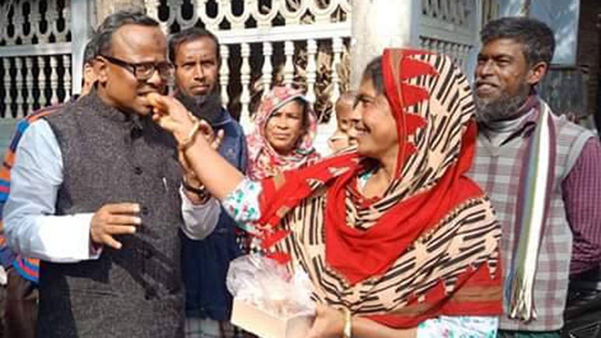 বিতরণ করা মিষ্টি শিবগঞ্জ পৌর মেয়র তৌহিদুর রহমানের মুখে তুলে দিচ্ছেন এক গ্রামবাসী। ছবি: সংগৃহীত