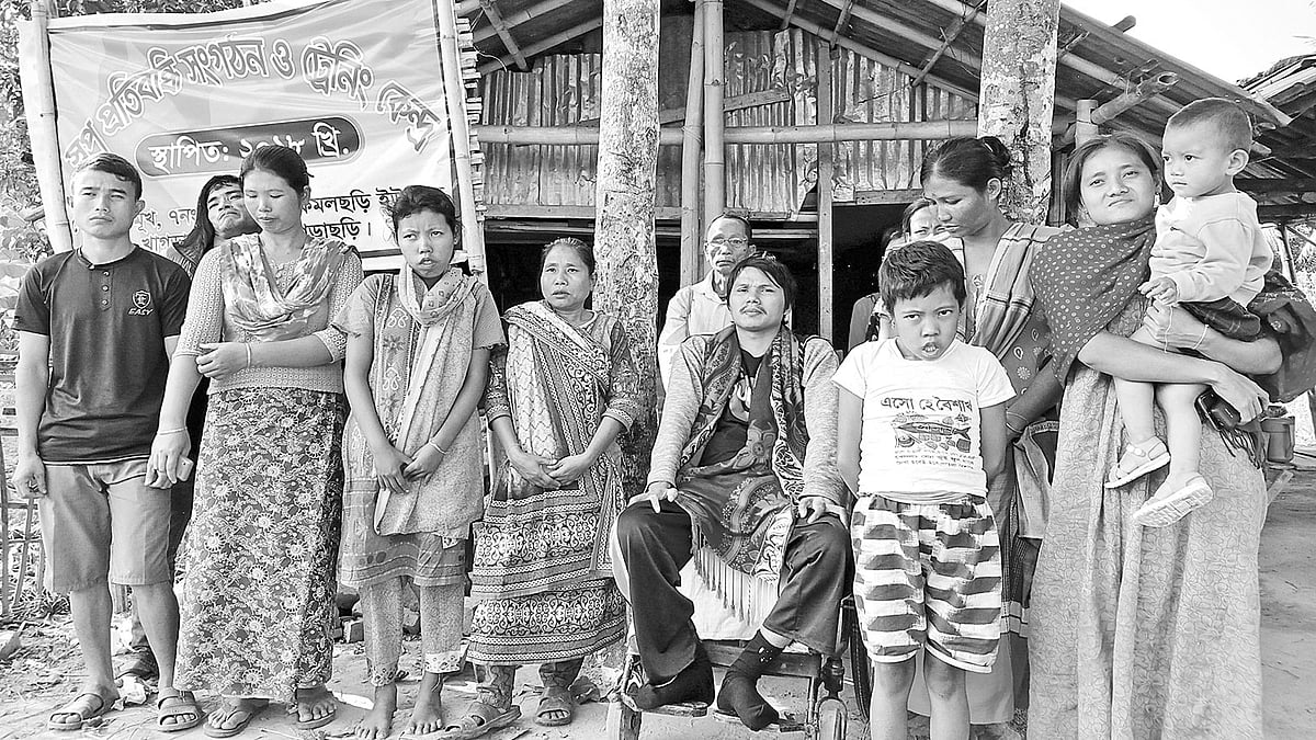 প্রতিবন্ধীদের সঙ্গে কিশোর চাকমা (হুইল চেয়ার বসা)। সম্প্রতি বেতছড়ি মুখ এলাকায় বাড়ির সামনে। প্রথম আলো