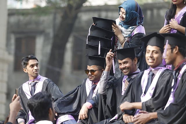 মাথায় টুপির ওপর টুপি সাজিয়েছেন একজন। পাশে অন্যরা। জগন্নাথ বিশ্ববিদ্যালয়, ঢাকা। ছবি: প্রথম আলো