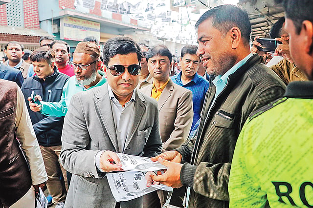 ভোটারদের হাতে লিফলেট দিচ্ছেন ফজলে নূর তাপস। গতকাল মানিকনগরে।  প্রথম আলো
