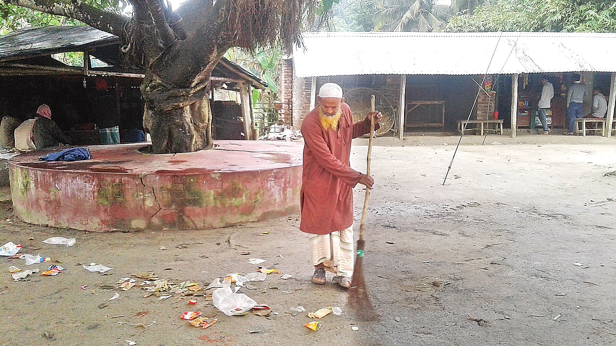 ঝিনাইদহের কালীগঞ্জে আদর্শ কৃষক হেলাল উদ্দিন ২৫ বছর ধরে বাজার পরিষ্কার করছেন নিজ হাতে ঝাড়ু দিয়ে। ছবিতে মহেশ্বরচাঁদা বাজার পরিষ্কার করতে দেখা যাচ্ছে। ছবি: প্রথম আলো