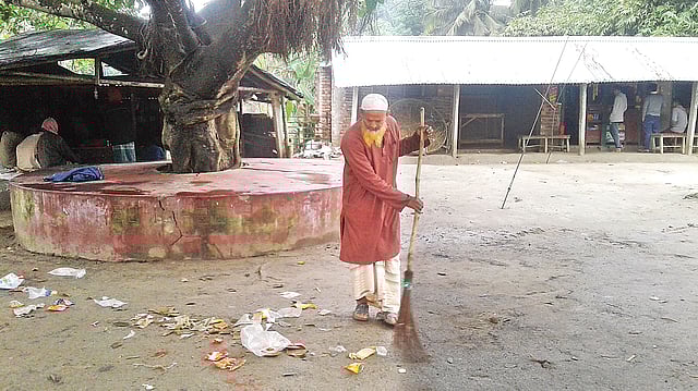 ঝিনাইদহের কালীগঞ্জে আদর্শ কৃষক হেলাল উদ্দিন ২৫ বছর ধরে বাজার পরিষ্কার করছেন নিজ হাতে ঝাড়ু দিয়ে। ছবিতে মহেশ্বরচাঁদা বাজার পরিষ্কার করতে দেখা যাচ্ছে।  ছবি: প্রথম আলো