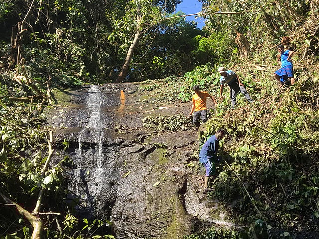 ঝরনার পাশ দিয়ে পাহাড় বেয়ে নামছেন কয়েকজন