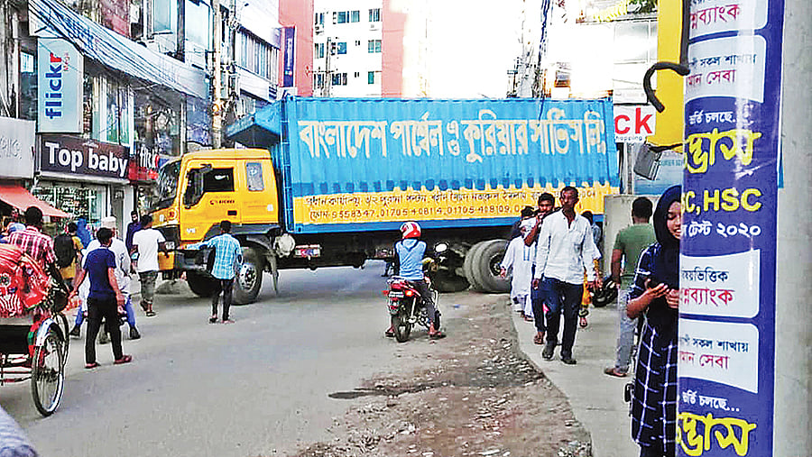 পার্সেলবাহী গাড়ি প্রবেশ করলেই এভাবে সড়কে প্রতিবন্ধকতা দেখা দেয়। সৃষ্টি হয় যানজটের। সম্প্রতি সিলেট নগরীর জিন্দাবাজার এলাকায়। ছবি: প্রথম আলো
