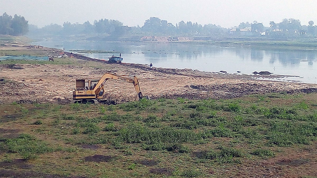 নওগাঁর মহাদেবপুর উপজেলায় আত্রাই নদের বন্যা নিয়ন্ত্রণ বাঁধের পাশ থেকে ভেকু দিয়ে মাটি কাটা হচ্ছে। এসব মাটি বিক্রি করা হচ্ছে বিভিন্ন ইটভাটায়। গত বৃহস্পতিবার উপজেলার শাহজাদপুর এলাকায়।  ছবি: প্রথম আলো