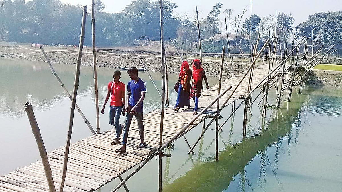 ফকিন্নী নদীর ওপর বাঁশের তৈরি সাঁকো। ভারী মালামাল নিয়ে নদী পার হতে ছয় কিলোমিটার ঘুরতে হয় গ্রামের বাসিন্দাদের। সম্প্রতি রাজশাহীর বাগমারার দহেরঘাটে। ছবি: প্রথম আলো