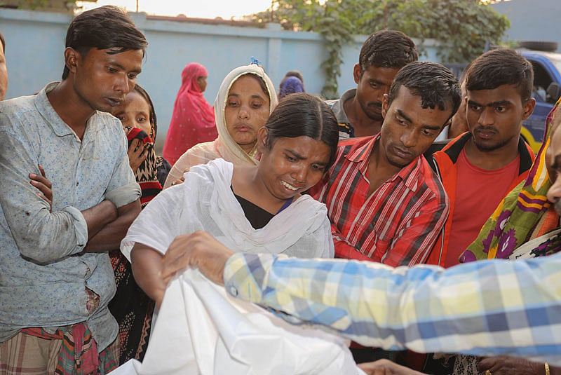 কাজ করতে গিয়ে বিদ্যুতায়িত হয়ে নিহত স্বজনকে দেখে শোকাহত তিনি। ছবি: জাহেদুল করিম