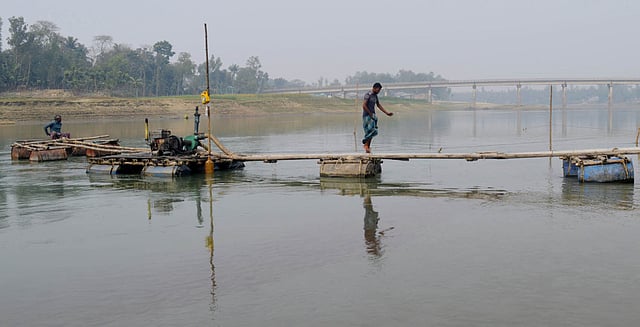 বগুড়ার ধুনট উপজেলায় বাঙ্গালী নদীর বিলচাপড়ি সেতু এলাকা থেকে খননযন্ত্র দিয়ে বালু তোলা হচ্ছে। গতকাল তোলা ছবি।  প্রথম আলো