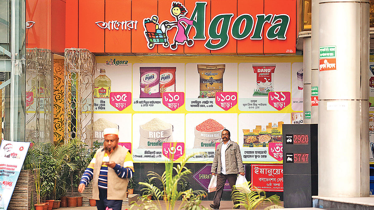 দেশের প্রথম সুপারশপ আগোরা বিক্রি হয়ে যাচ্ছে। ঢাকা, চট্টগ্রাম ও সিলেটে তাদের ১৭টি বিপণি বা স্টোর রয়েছে। ঢাকার সীমান্ত স্কয়ারের আগোরা থেকে কেনাকাটা করে বের হচ্ছেন ক্রেতারা। গতকাল বিকেলে।  ছবি: প্রথম আলো