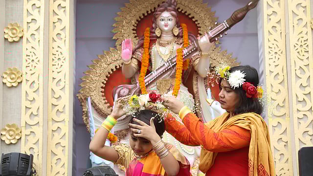 মেয়ের মাথায় ফুলের টায়রা পরিয়ে দিচ্ছেন এক মা।